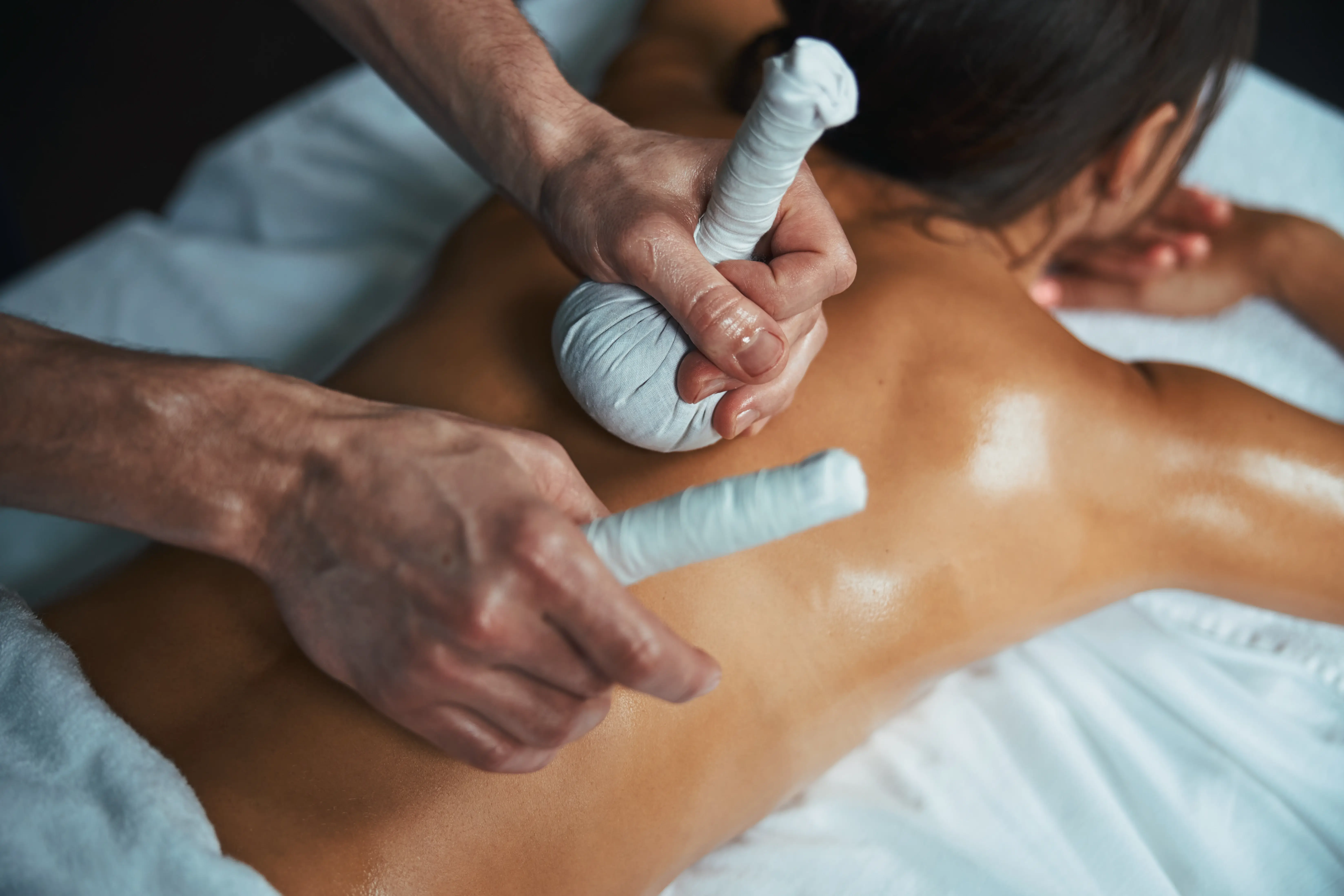 Warm rice bolus massage with milk and herbs for pain relief, muscle strengthening, and body healing, particularly effective in chronic fatigue, muscle weakness, joint pain, and improving overall vitality.